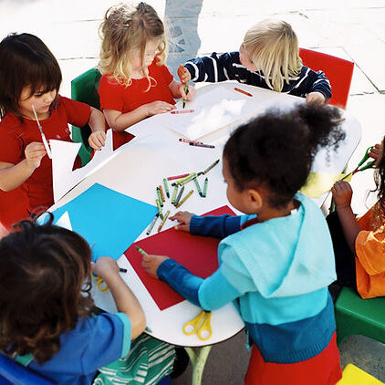 Group of kids around a table coloring