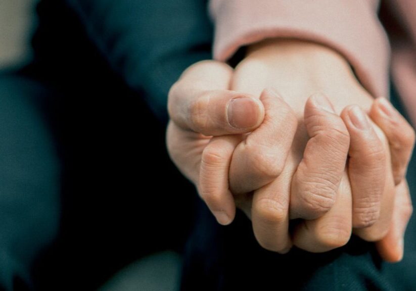 Photo by Sơn Bờm A close-up photo capturing two adult hands holding each other, symbolizing love and support.