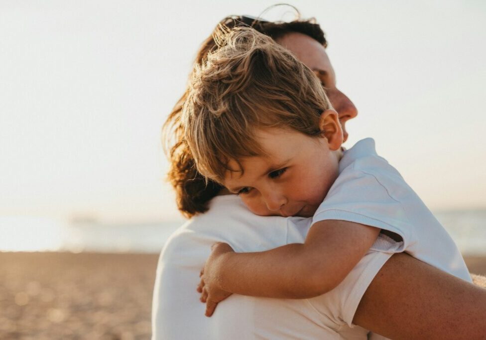 Photo by Xavier Mouton Photographie boy hugging woman during daytime